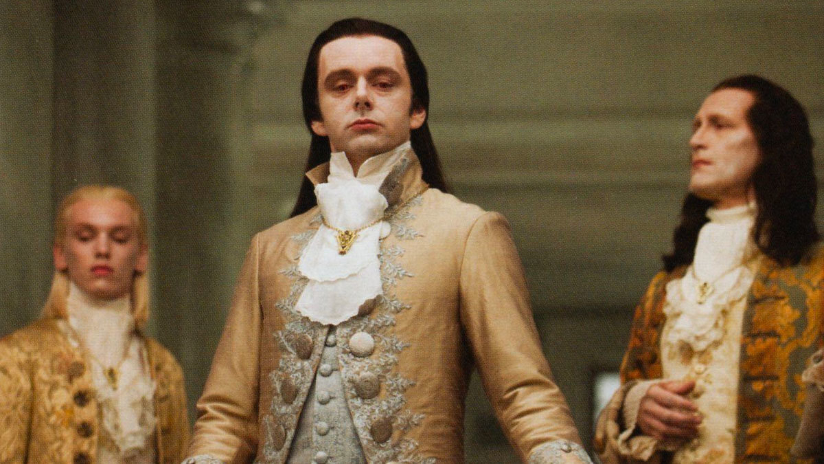 Three fancily dressed Volturi look down smugly from a balcony.